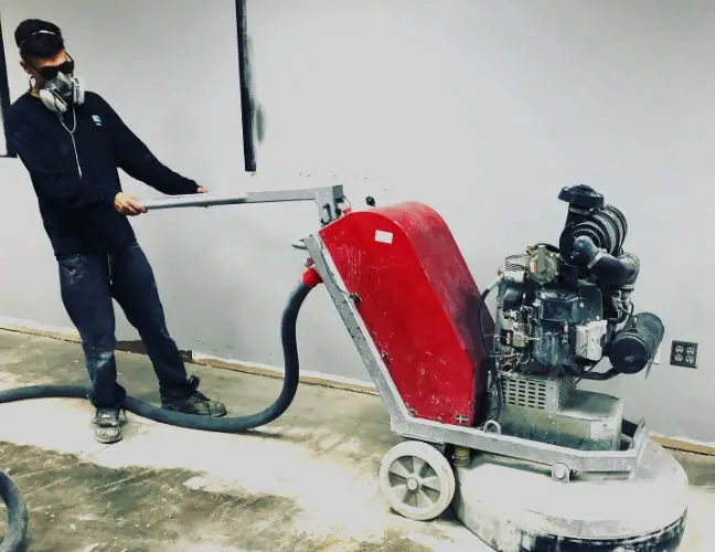 Worker using concrete grinding machine