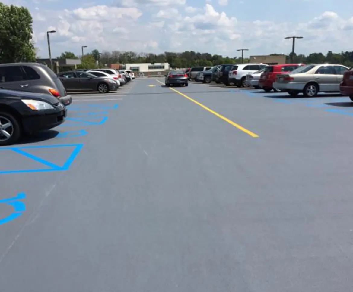 Outdoor parking lot with grey urethane coating and blue ADA markings