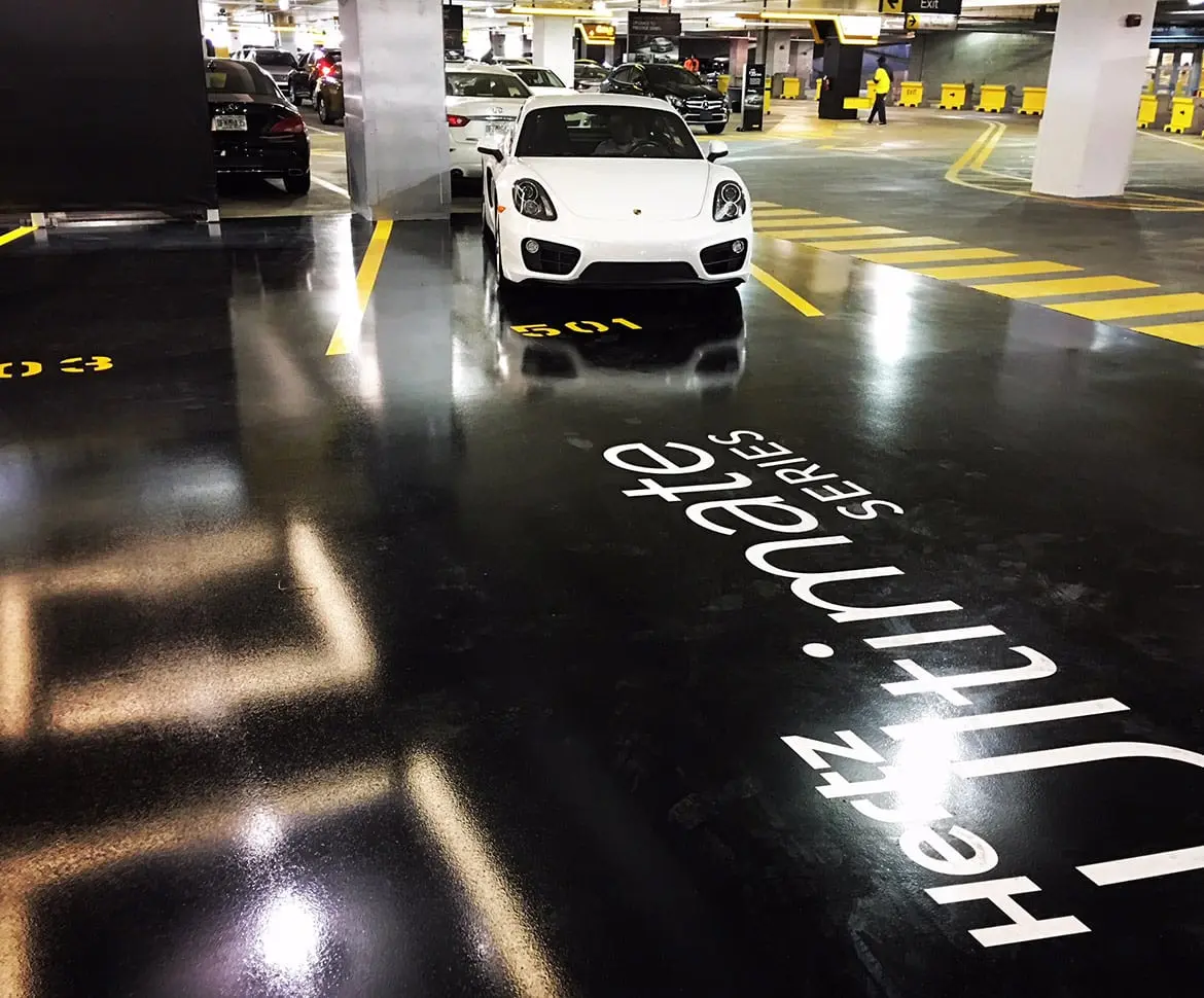Close-up of speckled epoxy chip garage floor with Mercedes wheel